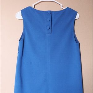 A short blue sleeveless dress with two pockets